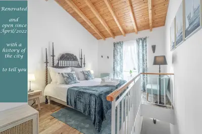 a bedroom with a bed and a staircase with a window at Main Street Apartments by Raspberry Cascade in Faro