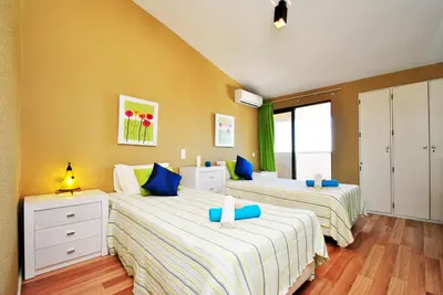 two beds in a room with yellow walls at Penthouse Miami by Algarve Vacation in Albufeira