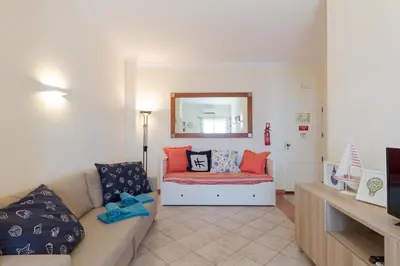 a living room with a couch and a mirror at Pé na Praia in Albufeira
