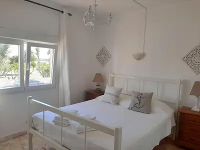 a bedroom with a white bed and a window at Beach Falésia Alfamar in Albufeira