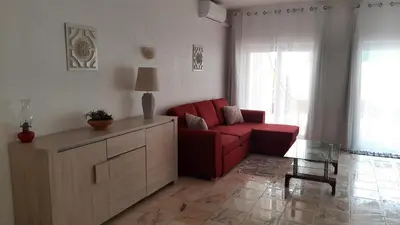 a living room with a red couch and a table at Beach Falésia Alfamar in Albufeira