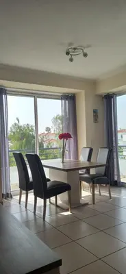a dining room with a table and chairs and windows at Casa Sensa in Albufeira