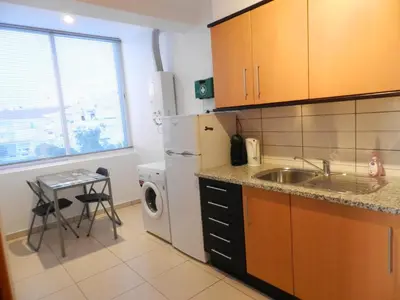 a small kitchen with a sink and a dishwasher at Casa Sensa in Albufeira