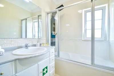a white bathroom with a sink and a shower at L14 by MTPhomes in Vale de Pedras