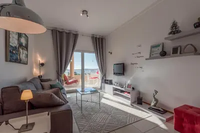 a living room with a couch and a tv at Beachfront flat, private parking, pools, sea at less than 200 m in Albufeira