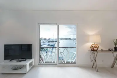 a living room with a tv and a large window at Boat View - Marina Plaza - By VilamouraSun in Vilamoura