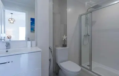 a white bathroom with a toilet and a shower at Boat View - Marina Plaza - By VilamouraSun in Vilamoura