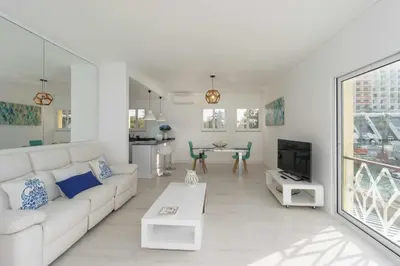 a living room with a white couch and a tv at Boat View - Marina Plaza - By VilamouraSun in Vilamoura