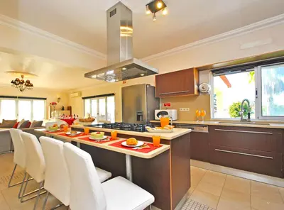 a kitchen with a island with white chairs in it at Villa Buddha by Algarve Vacation in Albufeira
