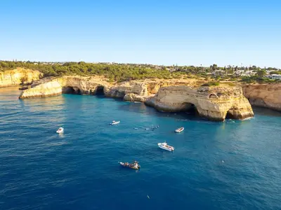 a group of boats in the water near cliffs at Villa Buddha by Algarve Vacation in Albufeira