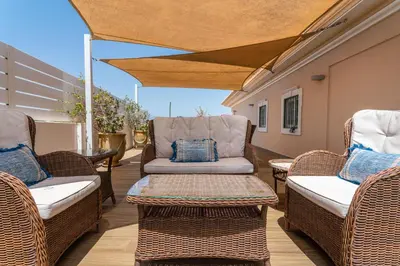 a patio with wicker chairs and a couch at Fonte Santa Villa in Quarteira