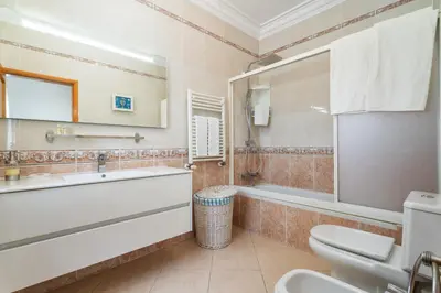 a bathroom with a tub and a toilet and a sink at Fonte Santa Villa in Quarteira