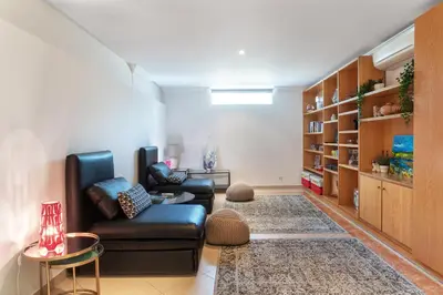 a living room with two chairs and a book shelf at Fonte Santa Villa in Quarteira