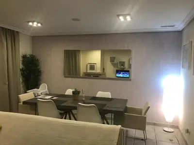 a dining room with a table and chairs and a mirror at Apartment Calcada in Albufeira