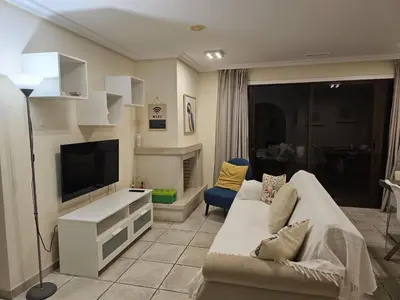 a living room with a couch and a television at Apartment Calcada in Albufeira
