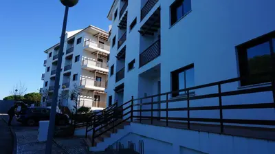 a white apartment building with a street light next to it at Apartment Calcada in Albufeira