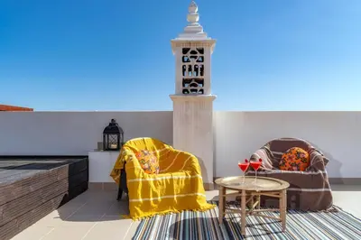 a living room with two chairs and a table at Mercedes Country House in Faro
