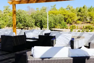 a group of white chairs sitting under a gazebo at Mercedes Country House in Faro