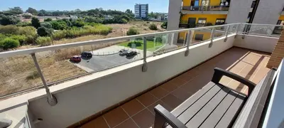 a balcony with a bench and a view of a yard at Varandas de Carteia in Quarteira