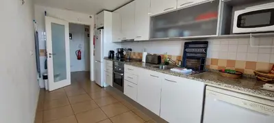 a kitchen with white cabinets and a microwave at Varandas de Carteia in Quarteira