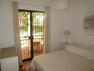 a bedroom with a bed and a sliding glass door at Casa Vila Verde in Quarteira