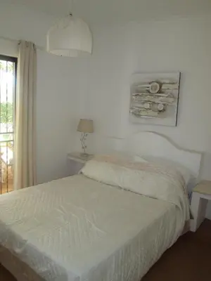 a bedroom with a white bed and a lamp at Casa Vila Verde in Quarteira