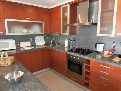 a kitchen with wooden cabinets and a stove top oven at Parque Atlântico in Quarteira