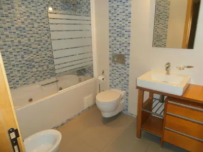 a bathroom with a toilet and a tub and a sink at Parque Atlântico in Quarteira