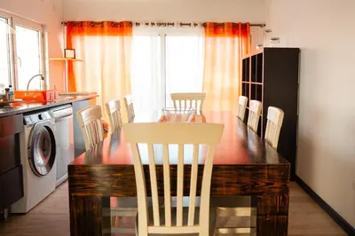 a kitchen with a table and chairs and a dining room at Wax Suite Life is a beach in Faro