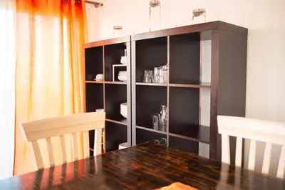 a dining room with a table and a book shelf at Wax Suite Life is a beach in Faro