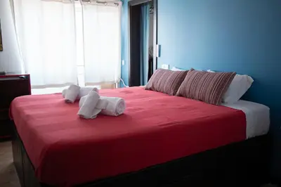 a bedroom with a red bed with towels on it at Wax Suite Life is a beach in Faro