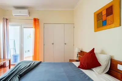 a bedroom with a bed with a blue comforter at Aqua Magna Apartment in Albufeira