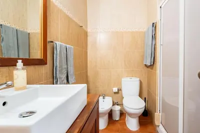 a bathroom with a white sink and a toilet at Aqua Magna Apartment in Albufeira