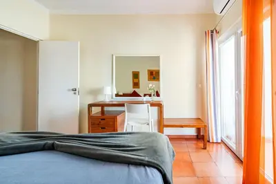 a bedroom with a bed and a desk and a mirror at Aqua Magna Apartment in Albufeira