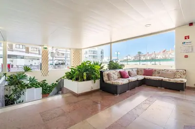 a large room with couches and plants in a building at Aqua Magna Apartment in Albufeira