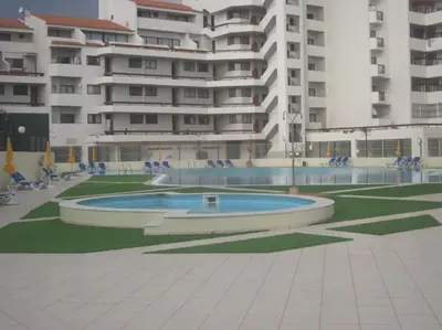 a swimming pool in front of a large building at Aqua Magna Apartment in Albufeira