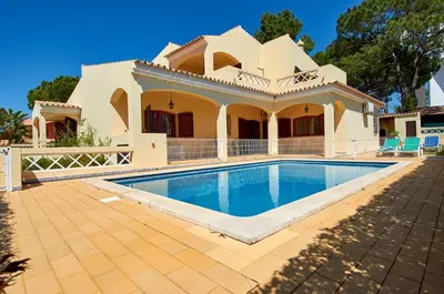 a house with a swimming pool in front of it at Charming House Vilamoura in Vilamoura