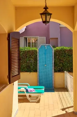 a patio with a blue door and a table and chairs at Charming House Vilamoura in Vilamoura