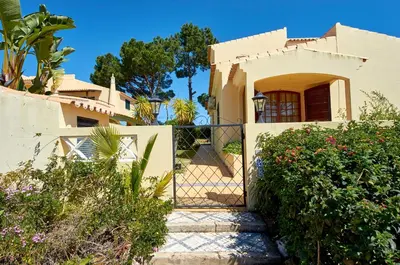 a gate to a house with a garden at Charming House Vilamoura in Vilamoura