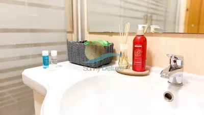 a bathroom sink with a bottle of detergent and a mirror at Oura Lancemar by Sunny Deluxe in Albufeira