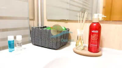 a bathroom counter with a bottle of shampoo and a basket ofds at Oura Lancemar by Sunny Deluxe in Albufeira
