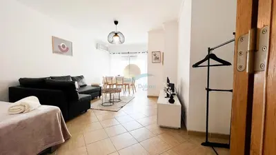 a living room with a black couch and a table at Oura Lancemar by Sunny Deluxe in Albufeira