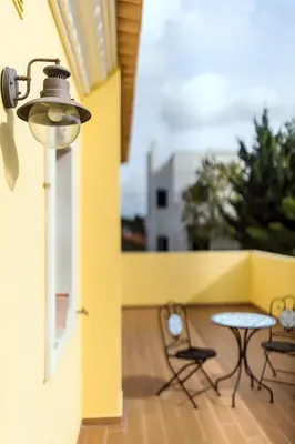 a patio with two chairs and a table on a balcony at Laguna Formosa in Faro