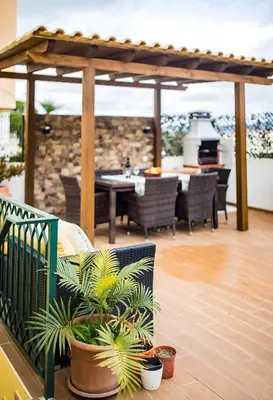 a patio with a grill and a table and chairs at Laguna Formosa in Faro