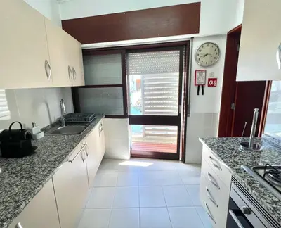 a kitchen with a sink and a clock on the wall at Casa Marum in Faro
