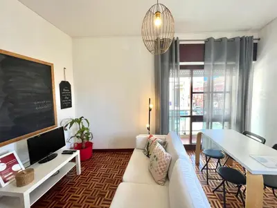 a living room with a white couch and a table at Casa Marum in Faro
