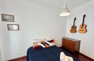 a bedroom with a bed and two guitars on the wall at Casa Marum in Faro
