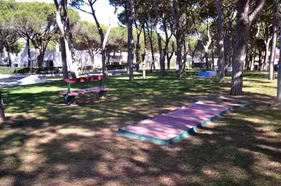 a park with a bench and trees and grass at Sailing Studio Açoteias in Albufeira