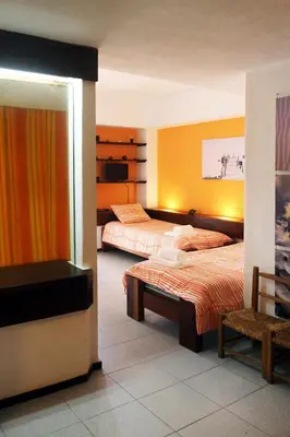 a bedroom with two beds and a chair in it at Acoteias Beach Studio in Albufeira