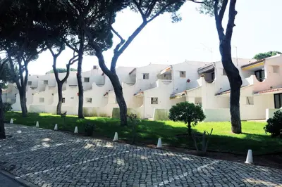 a row of trees in front of a building at Acoteias Beach Studio in Albufeira